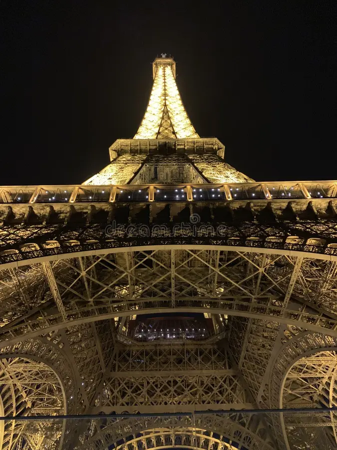 parís-francia-de-julio-vista-desde-abajo-la-torre-eiffel-por-noche-las-vigas-luz-dirigidas-hacia-arriba-lo-iluminan-el-interior-168651656
